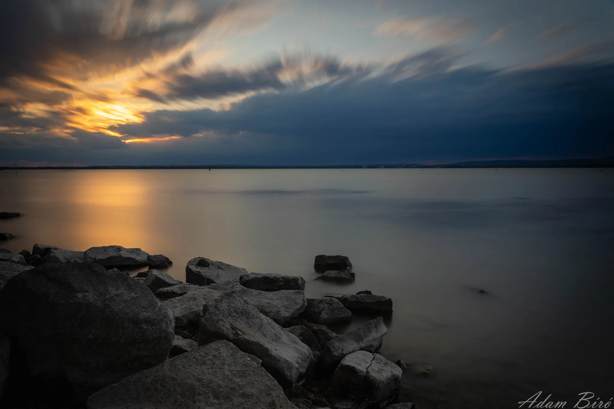 Minimal long exposure landscape of Lake Balaton at sunset with calm water and fading light